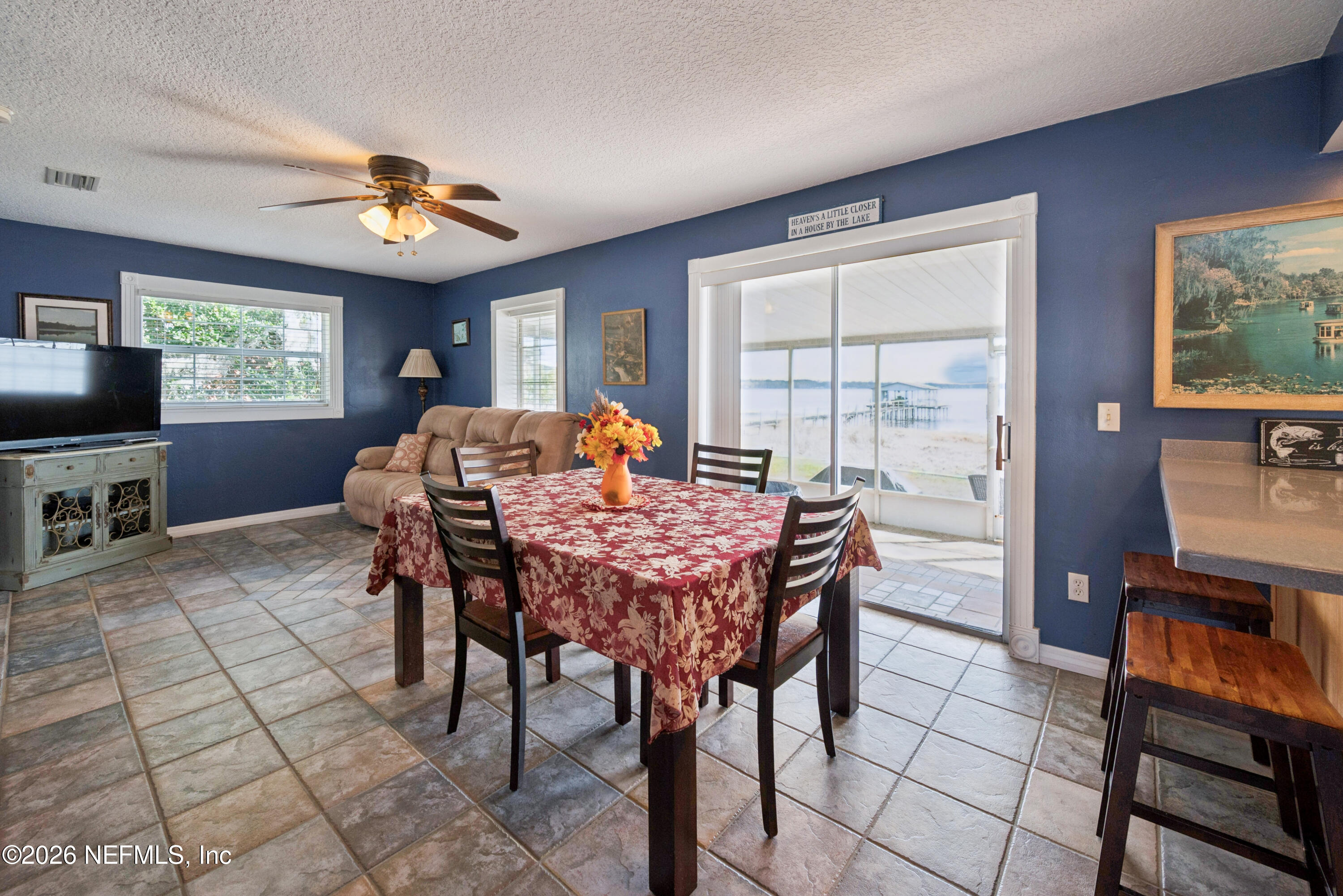 7932 Southwest County Road 18 Hampton, FL 32044 - Photo 9 of 39 a dining room with furniture a flat screen tv and a chandelier