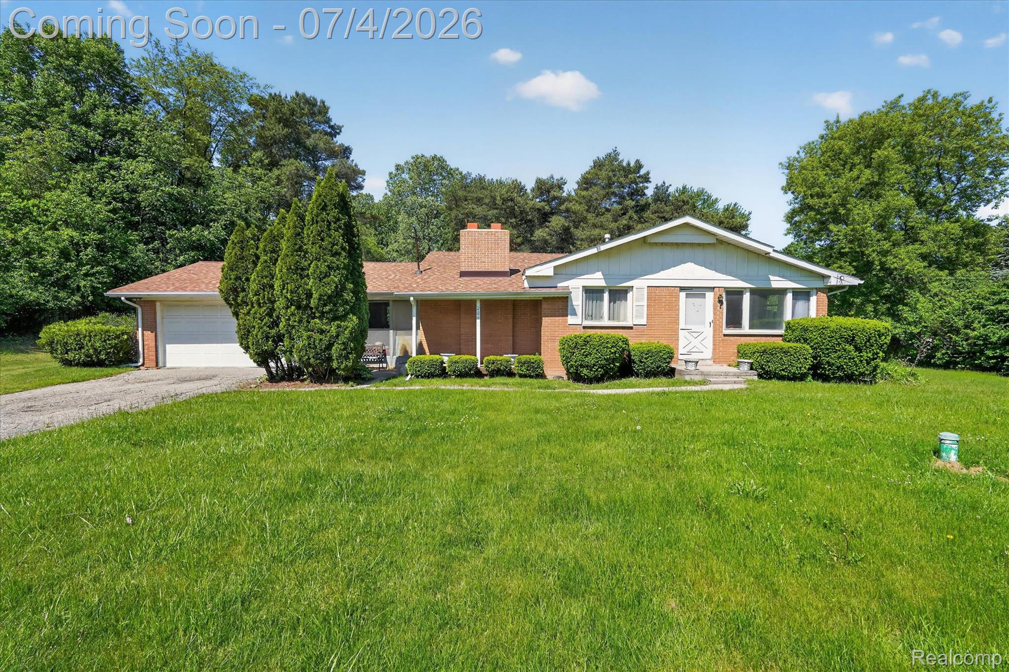 2091 North Irish Road Davison, MI 48423 - Photo 1 of 25 Brick ranch-style residence featuring a white garage door, gabled entry, and a gravel driveway