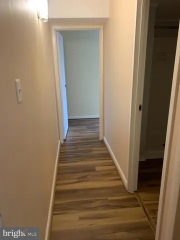 a view of a hallway with wooden floor and entryway