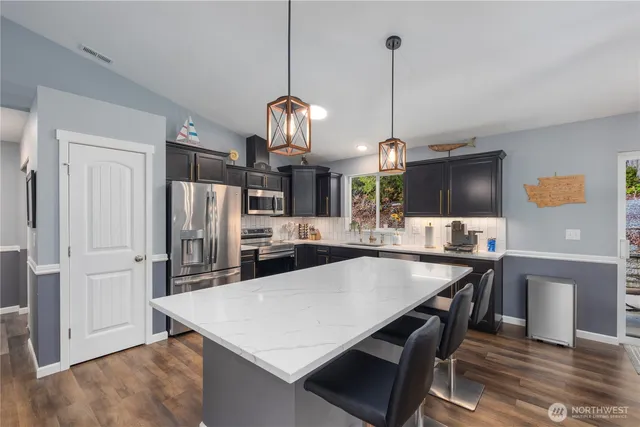 a kitchen with stainless steel appliances a sink stove and microwave