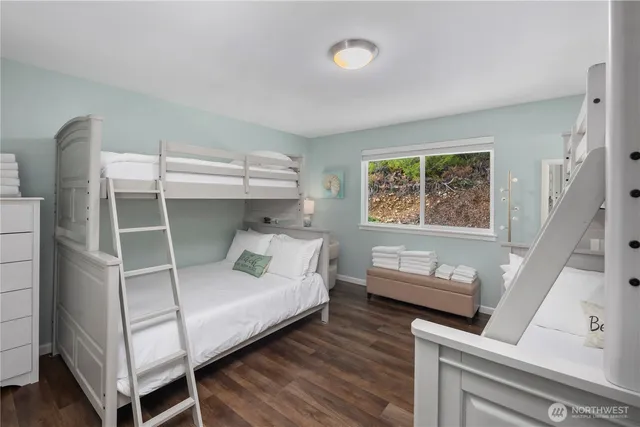 a spacious bedroom with a bed and wooden floor