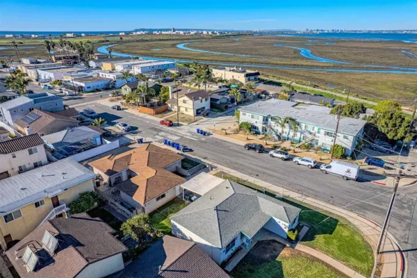 an aerial view of ocean and residential houses with outdoor space