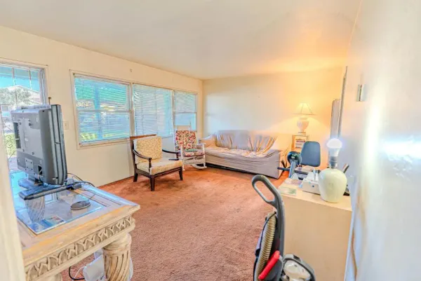 a living room with furniture a flat screen tv and a large window