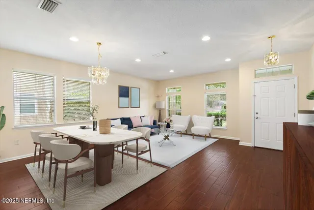 a view of a a dining room with furniture window and wooden floor