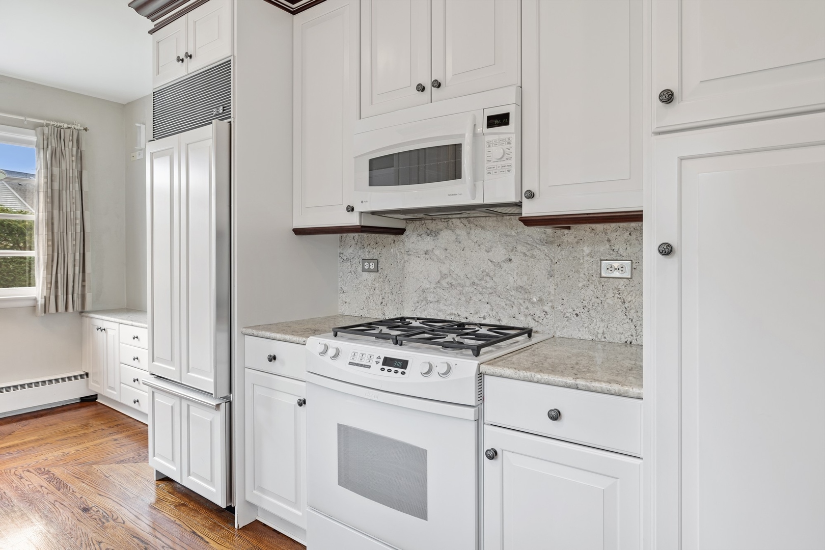 921 Pontiac Road Wilmette, IL 60091 - Photo 13 of 40 a kitchen with granite countertop white cabinets and white appliances