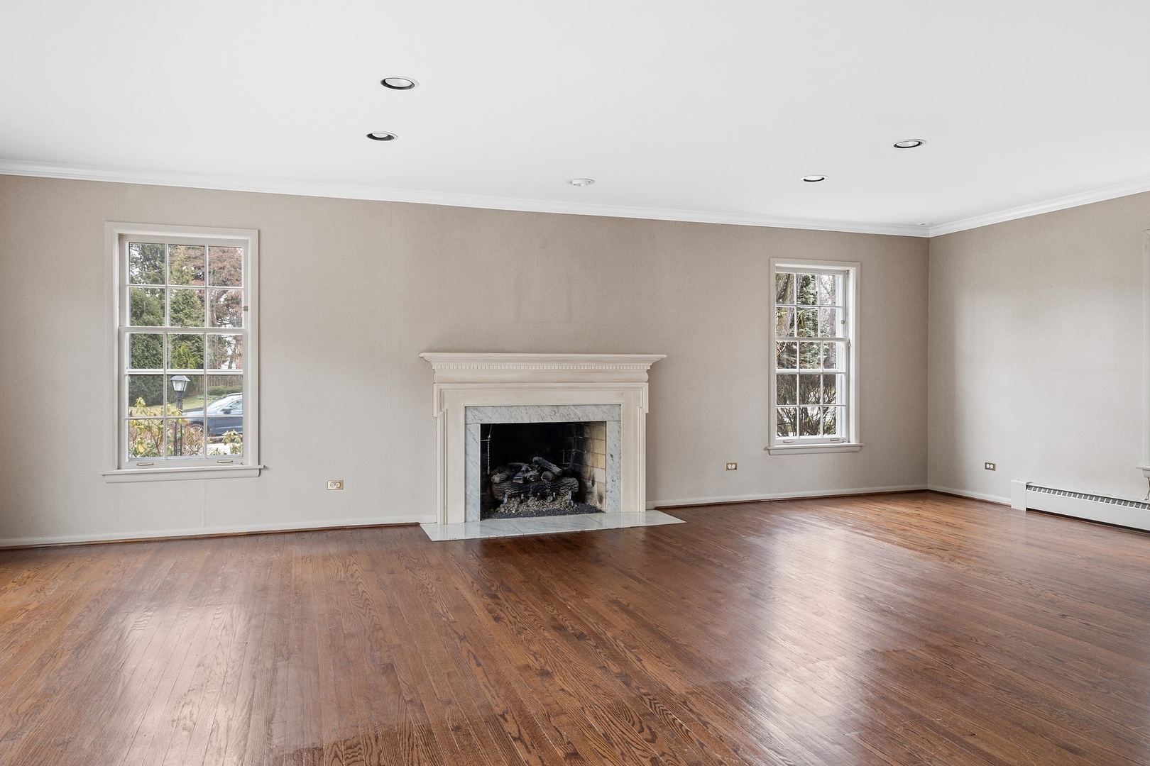 921 Pontiac Road Wilmette, IL 60091 - Photo 6 of 40 an empty room with wooden floor fireplace and windows
