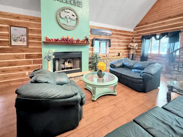 a living room with furniture a fireplace and a large window