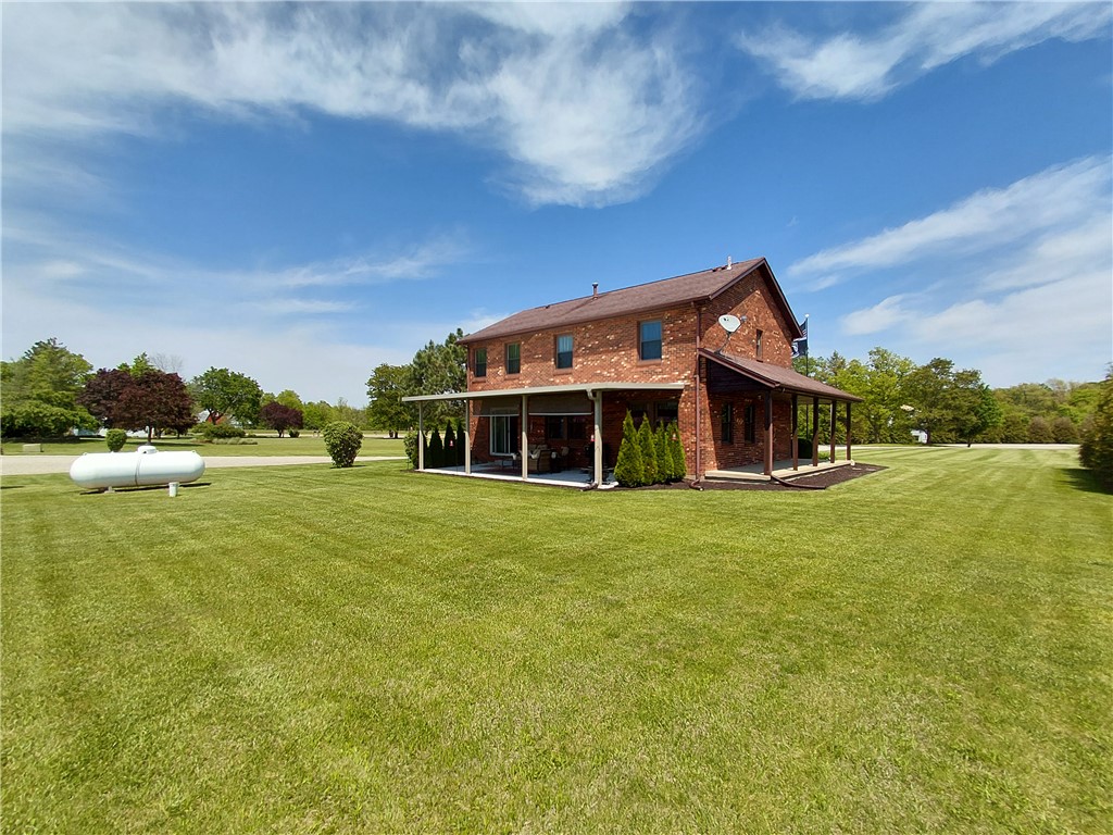 646 North Rangeline Road Pleasant Hill, OH 45359 - Photo 10 of 11 A brick residence with generous outdoor living spaces set amidst verdant grounds, offering peaceful rural enjoyment.