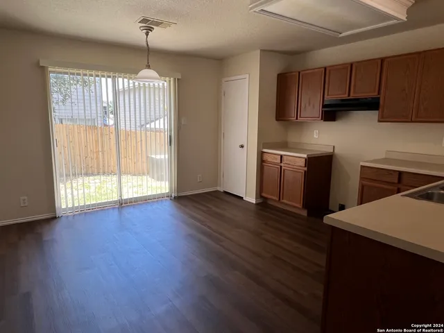 a kitchen with stainless steel appliances granite countertop wooden floors a stove and a microwave