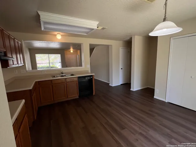 a kitchen with stainless steel appliances granite countertop a sink a stove a refrigerator and island with wooden floor