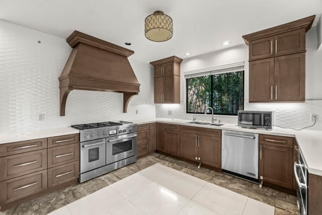 7339 Mandarin Drive Boca Raton, FL 33433 - Photo 12 of 47 a kitchen with granite countertop a stove a sink and a refrigerator