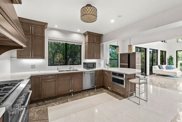 7339 Mandarin Drive Boca Raton, FL 33433 - Photo 9 of 47 a kitchen with sink stove and cabinets
