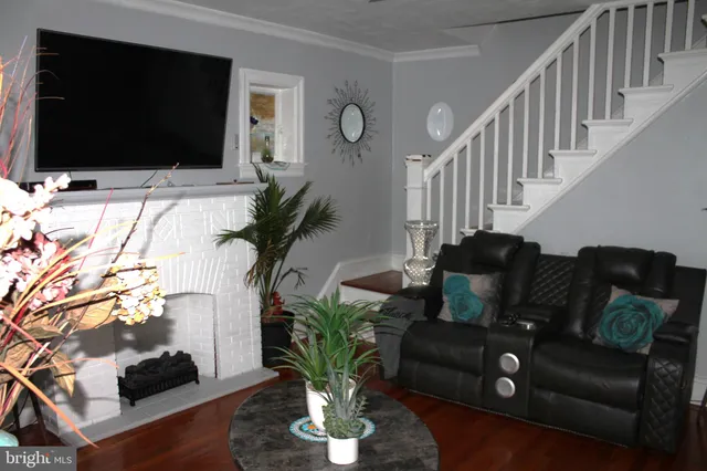 a living room with furniture potted plants and a flat screen tv