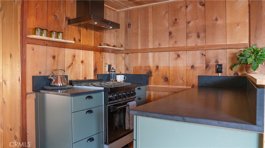 25201 Fern Valley Road Idyllwild, CA 92549 - Photo 28 of 34 a kitchen with stainless steel appliances granite countertop a stove a sink and a refrigerator with wooden cabinets