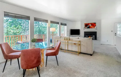 a living room with furniture a flat screen tv and a floor to ceiling window