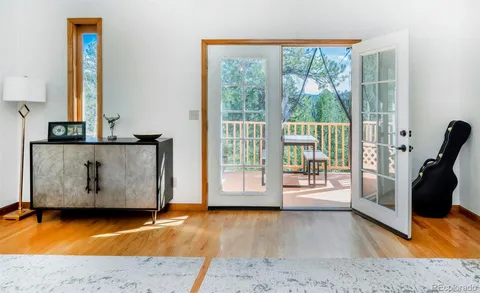 a view of a living room with a floor to ceiling window and wooden floor