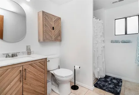 a bathroom with a toilet a sink and mirror