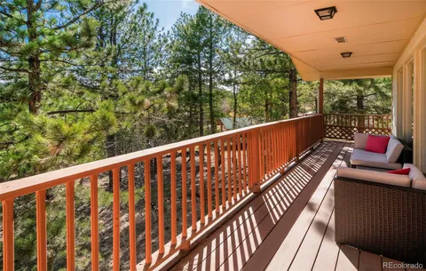 a balcony with wooden floor and outdoor seating