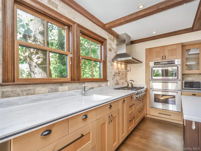 a kitchen with stainless steel appliances granite countertop a sink and a large window