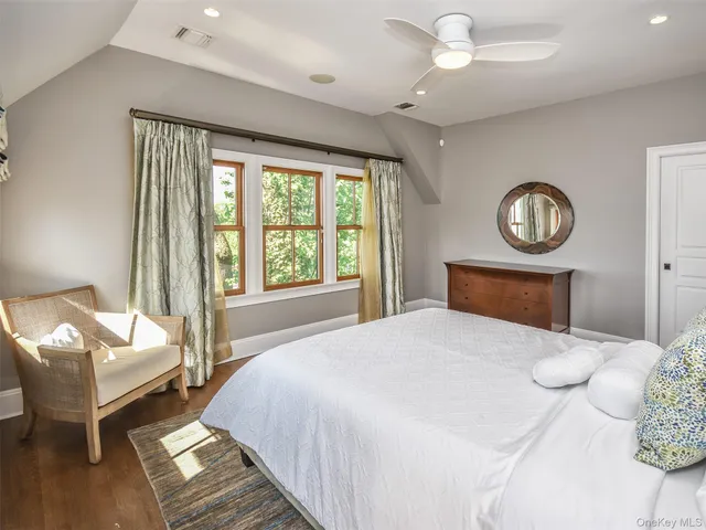 a bedroom with a bed mirror and a large window