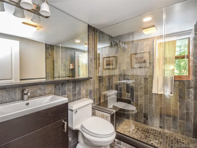 a bathroom with a sink toilet a mirror and shower