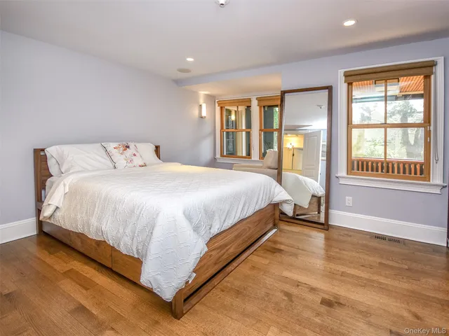 a bed sitting in a spacious bedroom next to a window