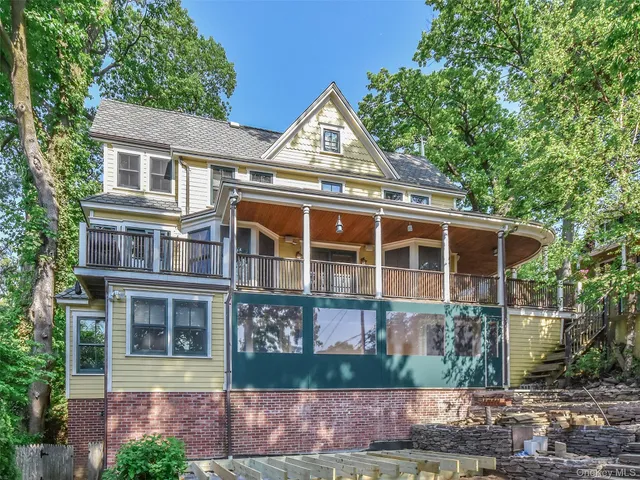 a view of a brick house with large windows and a small yard