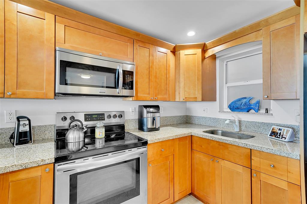 400 North Surf Road, Unit 703 Hollywood, FL 33019 - Photo 19 of 50 a kitchen with stainless steel appliances granite countertop a sink stove and microwave