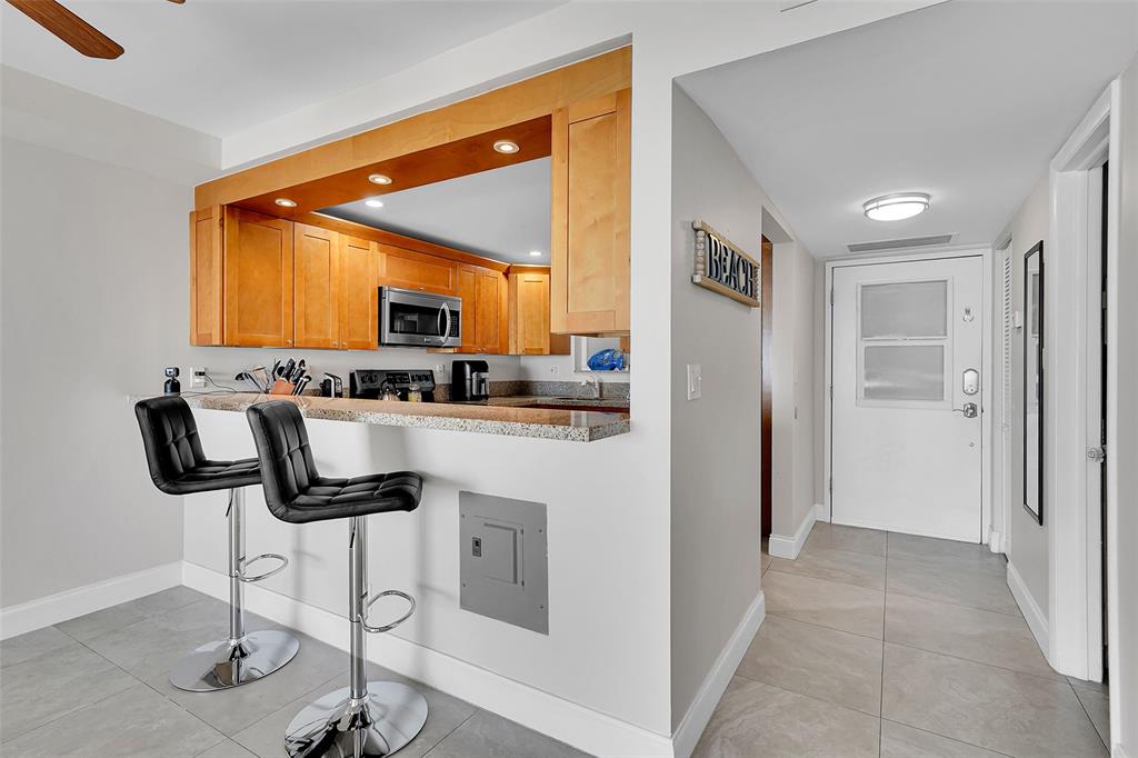 400 North Surf Road, Unit 703 Hollywood, FL 33019 - Photo 23 of 50 a kitchen with stainless steel appliances granite countertop a refrigerator a stove and a sink with wooden floor