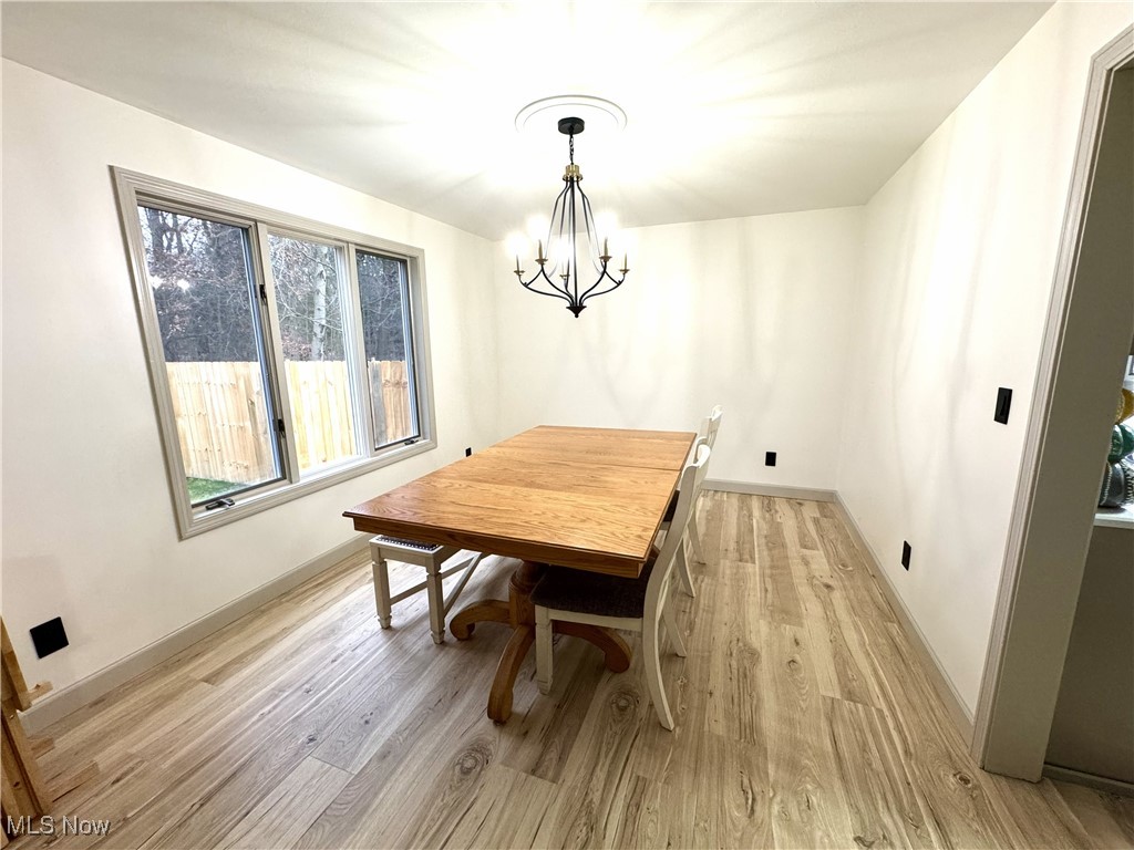 8359 Gibson Road Canfield, OH 44406 - Photo 10 of 27 Dining space with light wood-style flooring and a chandelier