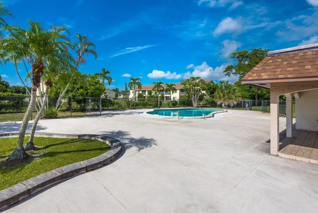 a view of road with house and trees in the background
