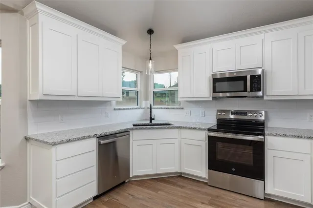 a kitchen with white cabinets and white appliances