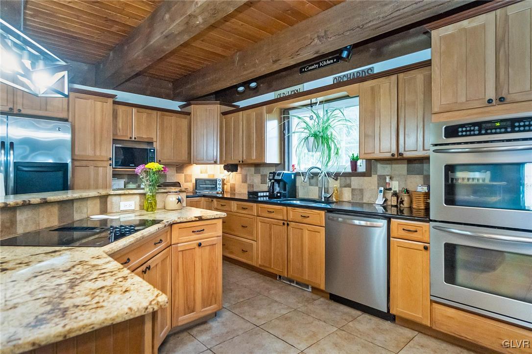 115 Pine Cove Court Lehighton, PA 18235 - Photo 31 of 49 a kitchen with granite countertop wooden cabinets stainless steel appliances a window and a sink