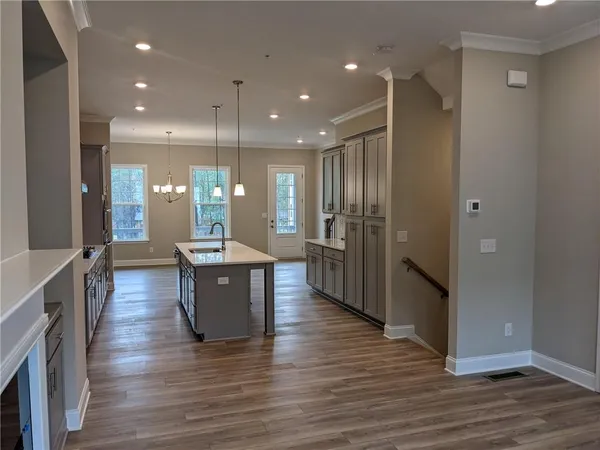 a large kitchen with lots of counter space a sink and stainless steel appliances