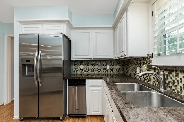a kitchen with a refrigerator sink and cabinets