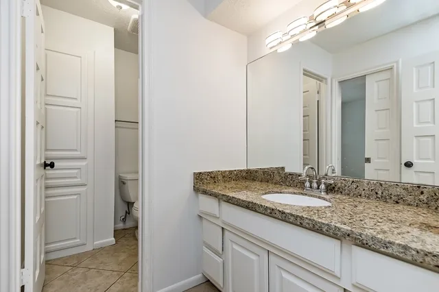 a bathroom with a granite countertop sink and a mirror