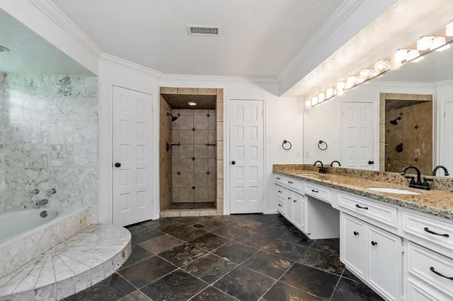 a spacious bathroom with a granite countertop sink a mirror and a bathtub