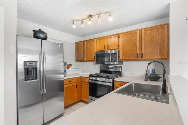 a kitchen with stainless steel appliances granite countertop a sink stove and refrigerator