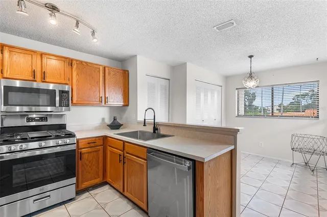 a kitchen with stainless steel appliances granite countertop a sink stove and microwave