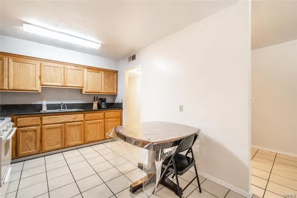 a kitchen with a stove a sink and white cabinets