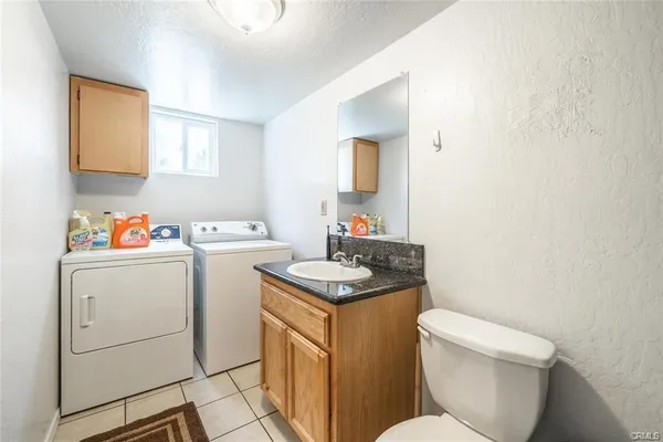 a bathroom with a granite countertop toilet sink and mirror