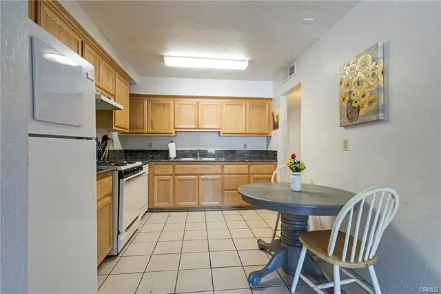 a kitchen with a refrigerator sink stove and cabinets