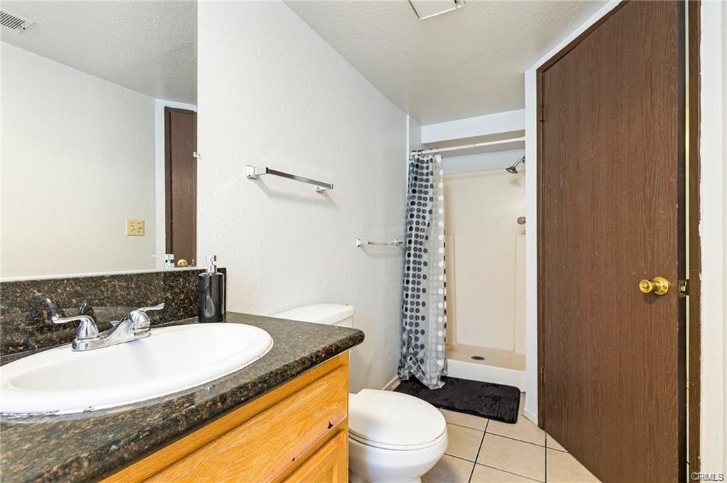 609 Rancheria Drive Chico, CA 95926 - Photo 36 of 60 a bathroom with a granite countertop sink toilet a mirror and shower