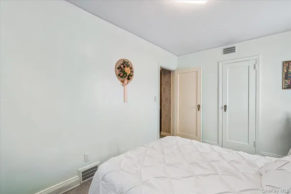 a bedroom with bed and a mirror