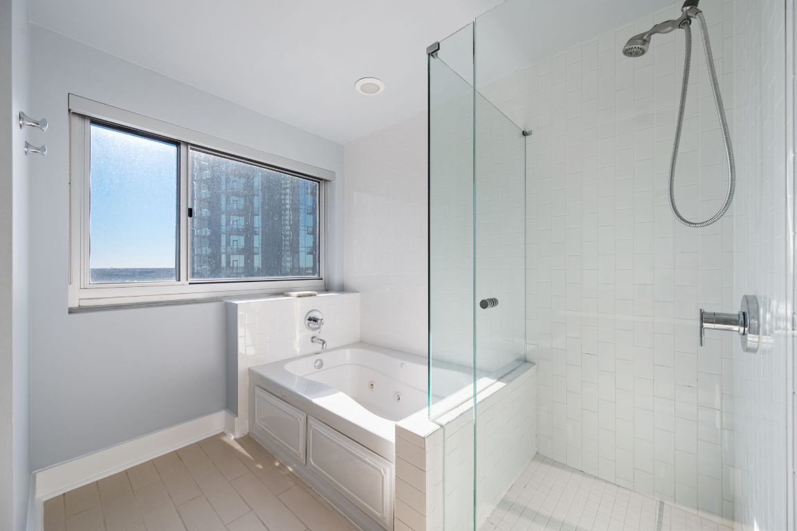 603 Davis Street, Unit 2009 Austin, TX 78701 - Photo 21 of 37 a bathroom with a granite countertop sink a mirror and shower