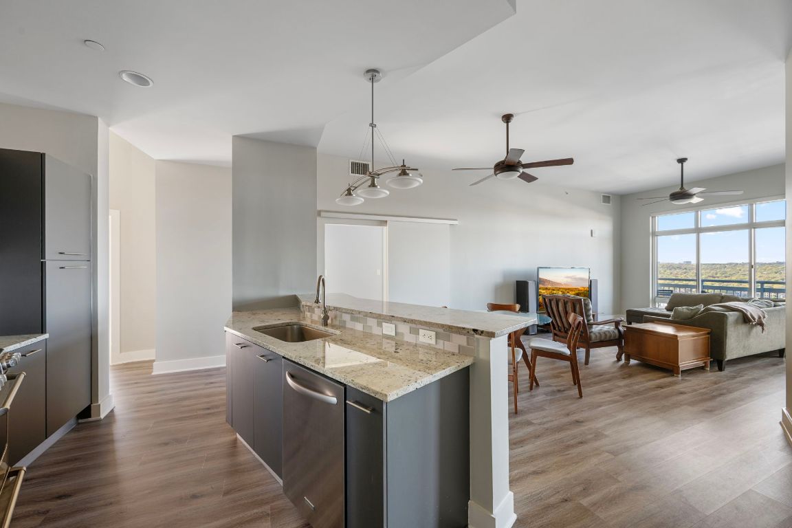 603 Davis Street, Unit 2009 Austin, TX 78701 - Photo 6 of 37 a kitchen with stainless steel appliances granite countertop a sink and a wooden floor