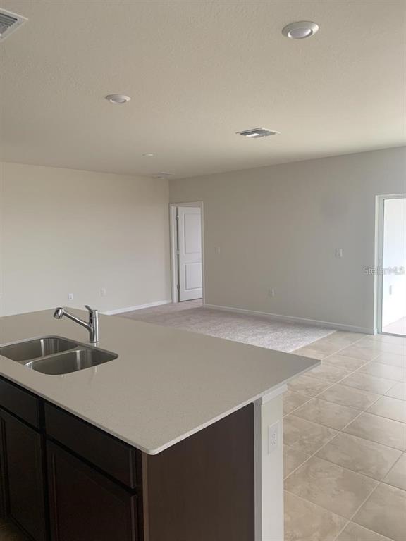 7363 Catania Loop Clermont, FL 34714 - Photo 4 of 12 a kitchen with a sink dishwasher and a refrigerator with wooden floor