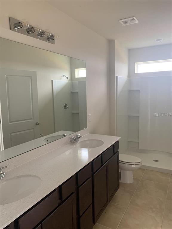 7363 Catania Loop Clermont, FL 34714 - Photo 8 of 12 a bathroom with a sink a toilet and shower