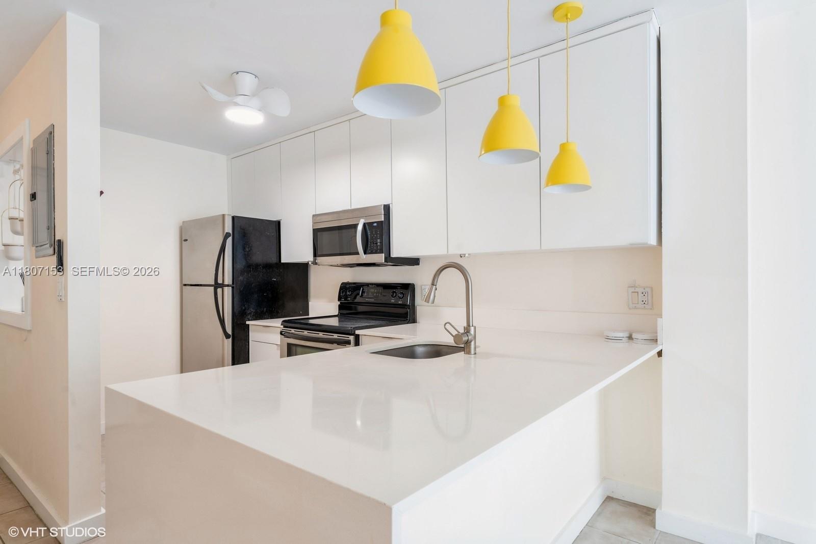 750 Northeast 64th Street, Unit B308 Miami, FL 33138 - Photo 15 of 25 a kitchen with stainless steel appliances a sink a microwave a refrigerator and a stove