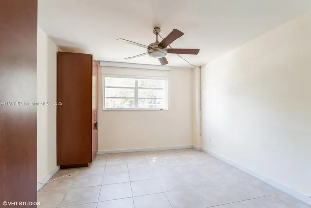 an empty room with windows and fan